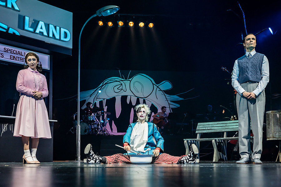 Drei Schauspieler auf einer Bühne.